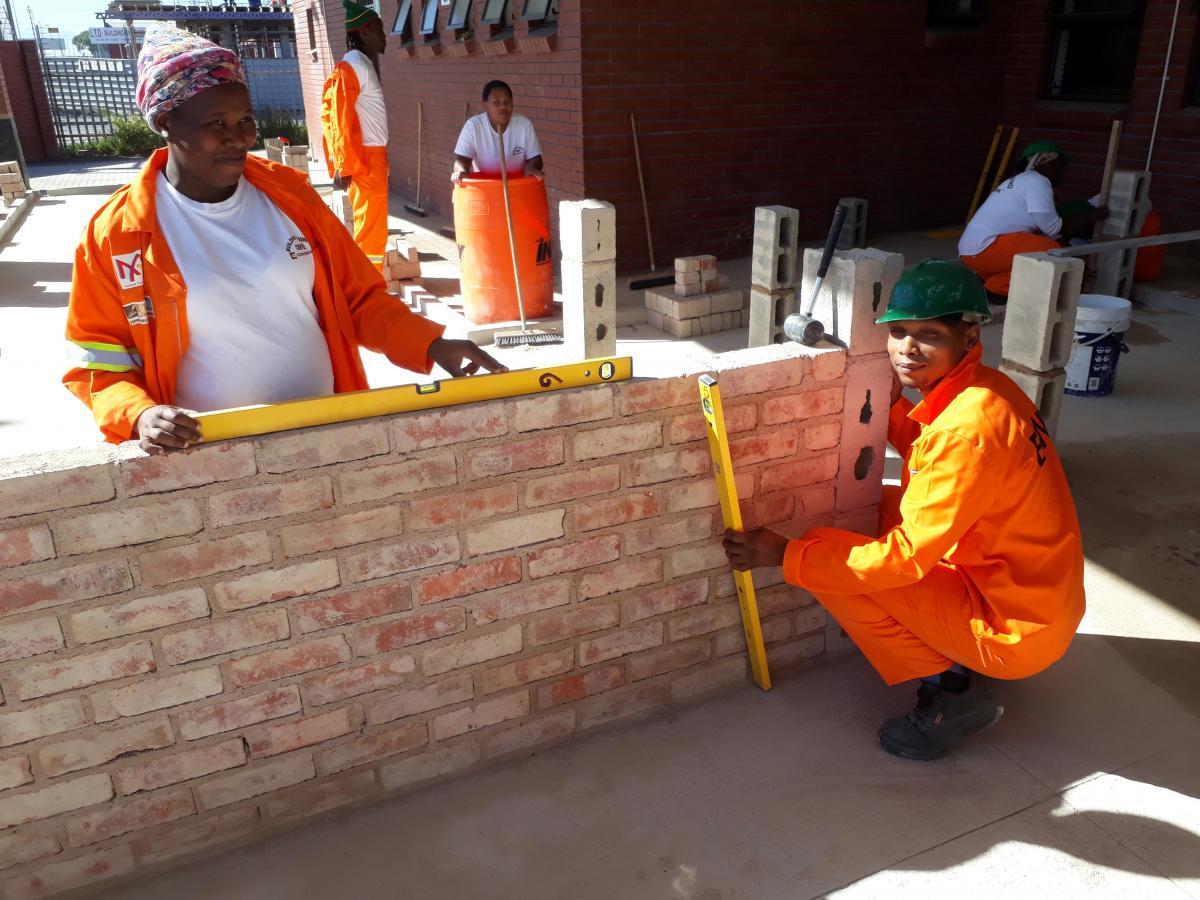 Builders checking brickwork with spirit levels