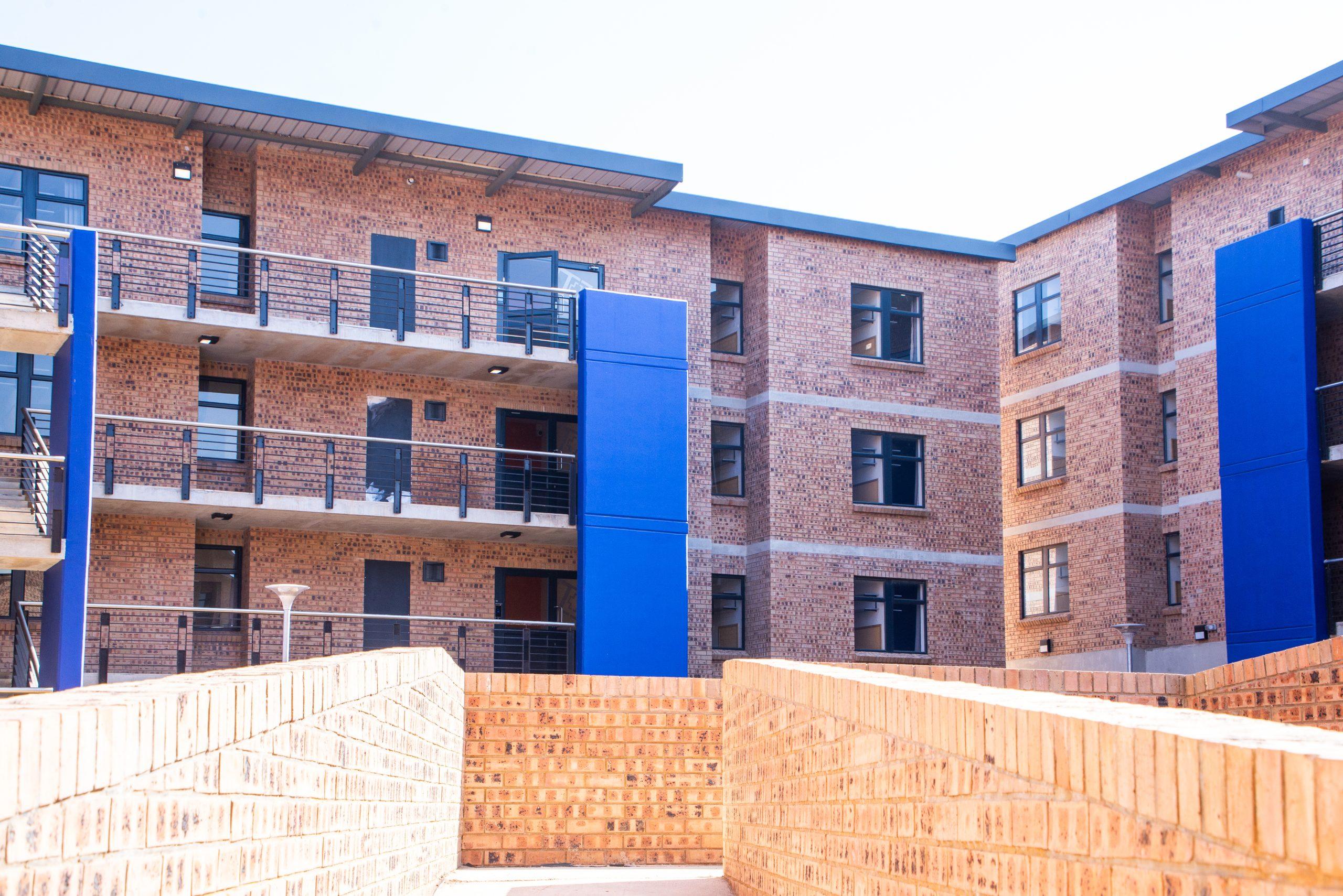 Completed brick apartment building with blue architectural features